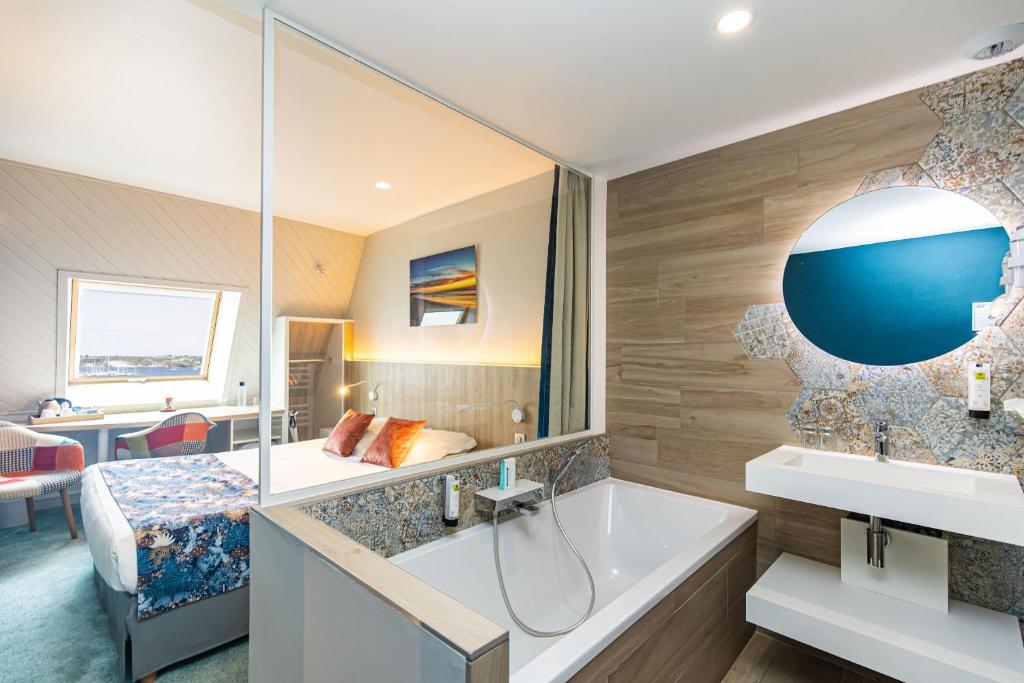 a bathroom with a tub and a bedroom at Hôtel de France in Camaret-sur-Mer