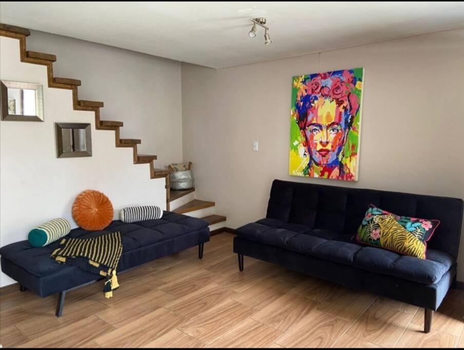 - un salon avec deux canapés bleus et un escalier dans l'établissement Casa Central en Villarrica, à Villarrica