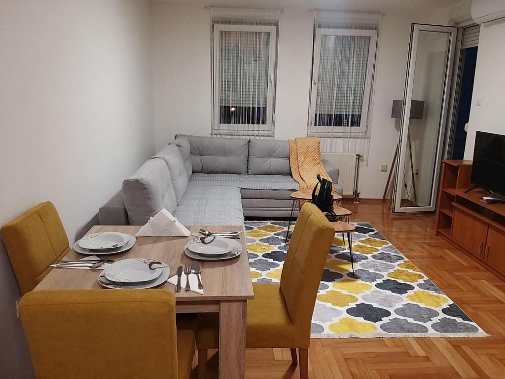 a living room with a table and a couch at Apartmani Elix in Banja Luka