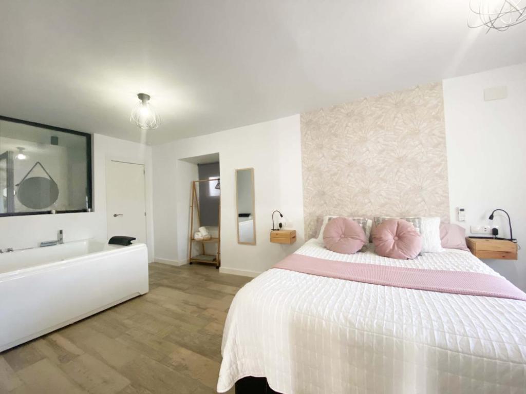 een witte slaapkamer met een groot bed en een bad bij Amores Loft Rural in Alcalá de los Gazules