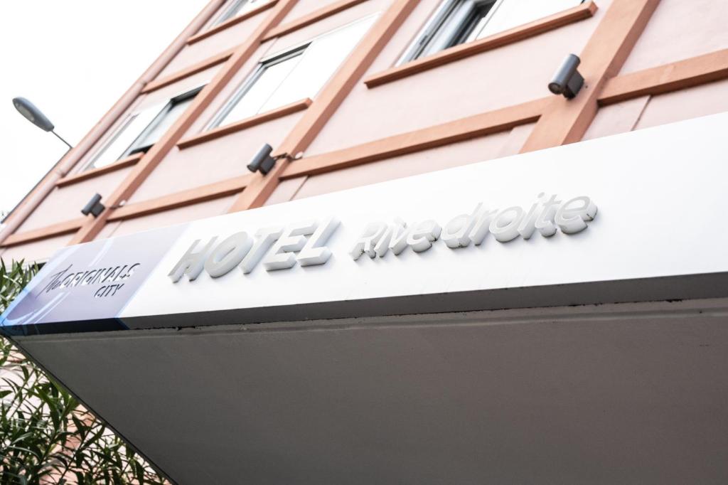um sinal para um hotel na lateral de um edifício em The Originals City, Hôtel Rive Droite, Albi "Quartier Madeleine" em Albi