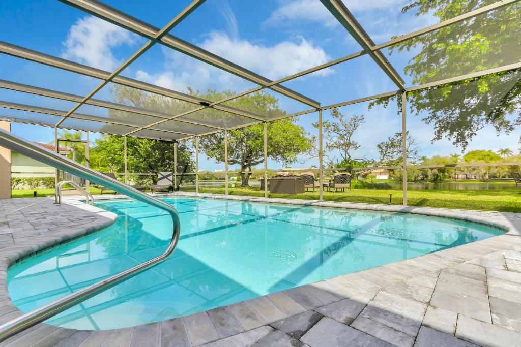 una piscina cubierta con techo de cristal en WatersEdge -handicap friendly, screened private pool, en Weston