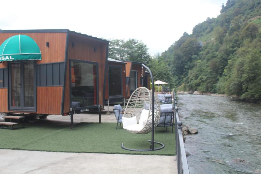 an rv parked next to a river with a swing at Akasya Tiny House in Ardeşen