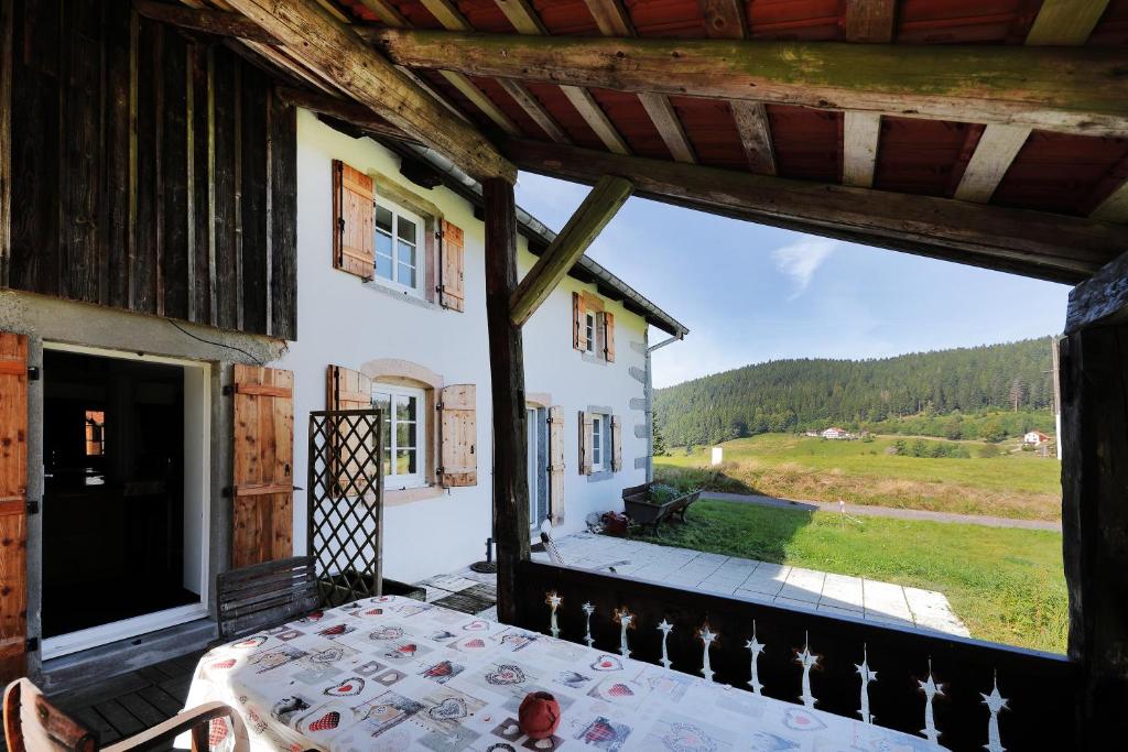 uma vista do alpendre de uma casa com uma mesa em Chez Odile - Charmante ferme rénovée em Gérardmer