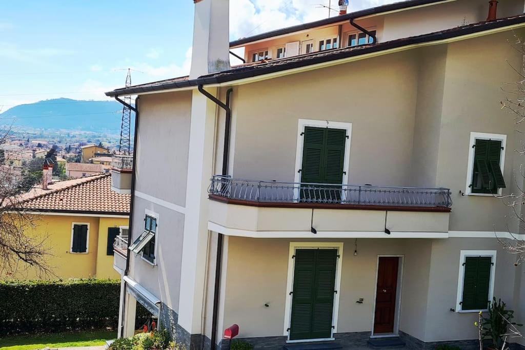 ein Gebäude mit grünen Rollläden und einem Balkon in der Unterkunft casa vacanza da Menan in Castelnuovo Magra