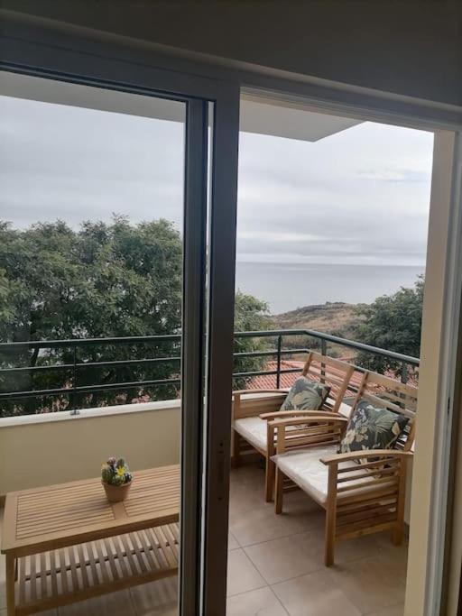 a balcony with benches and a view of the ocean at Caniço Ocean Getaway in Caniço