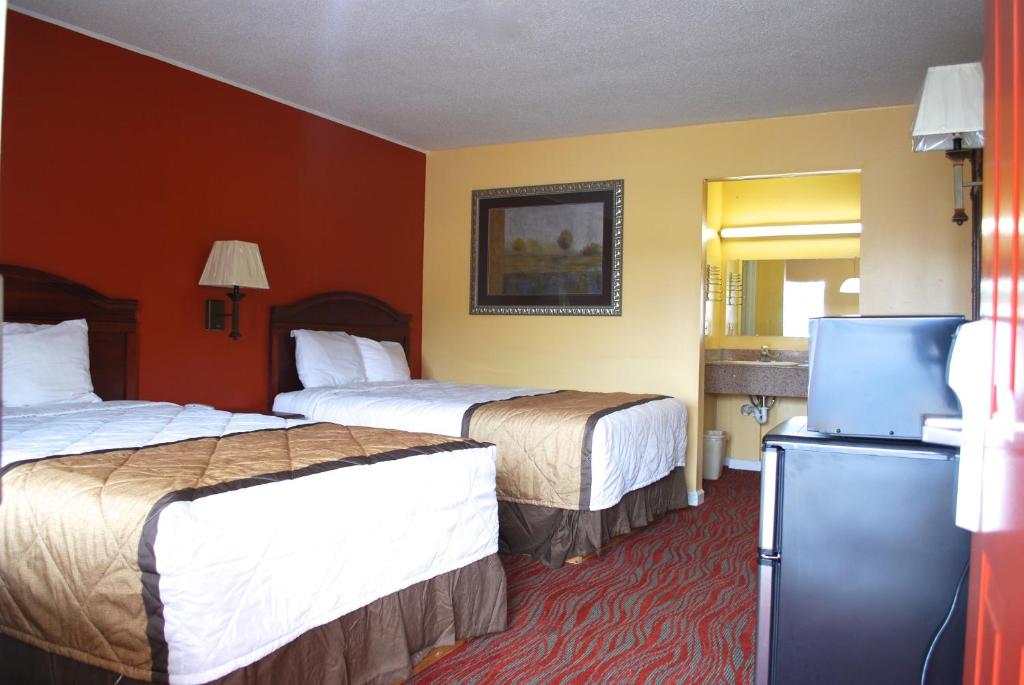 a hotel room with two beds and a refrigerator at Duffys Motel - Calhoun in Calhoun