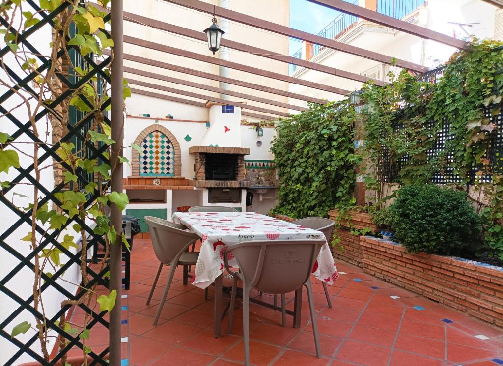 d'une terrasse avec une table, des chaises et un four extérieur. dans l'établissement Casa de la Portuguesa, bonita terraza con barbacoa, à Güéjar-Sierra