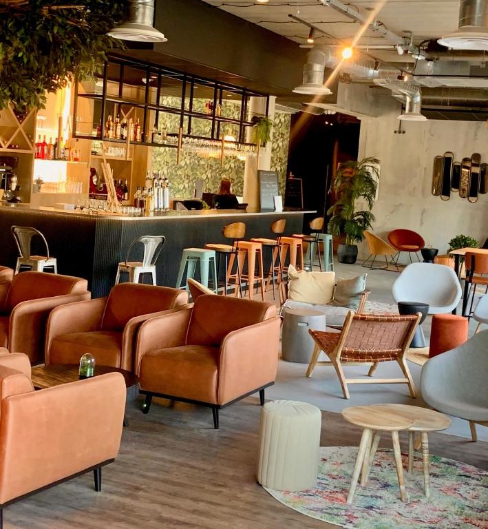 a room with couches and tables and a bar at Campanile Saint Brieuc - Centre Gare in Saint-Brieuc