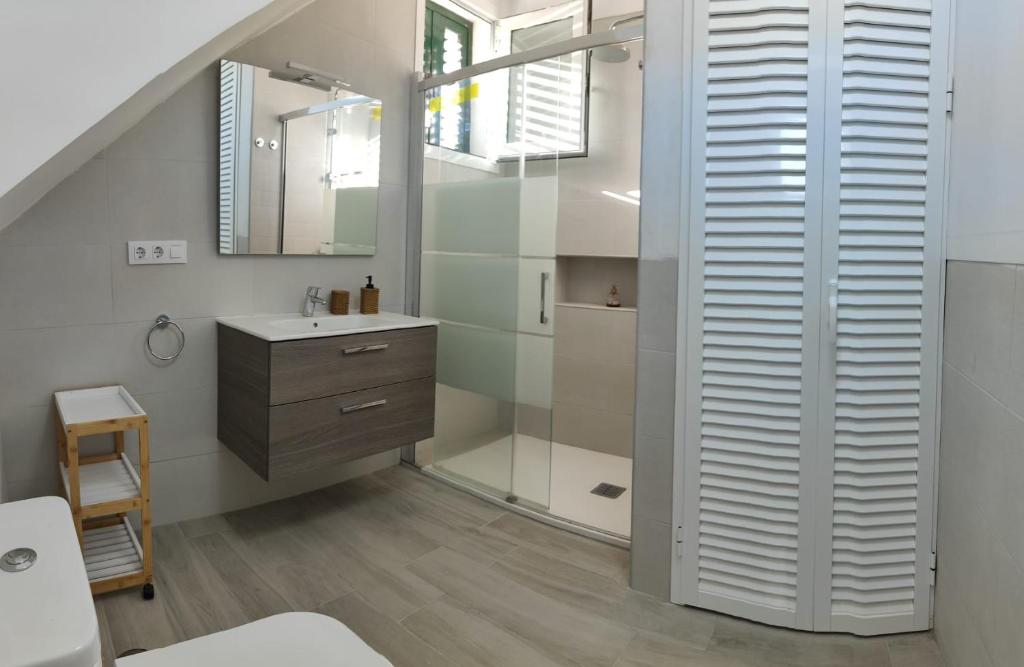ein Bad mit einem Waschbecken, einer Dusche und einem Spiegel in der Unterkunft Vistamar in Las Eras