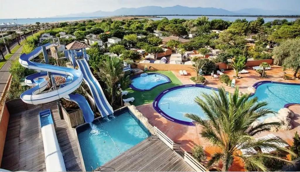 uma vista aérea de um resort com duas piscinas em Mobil-home 5 personnes dans camping Mar Estang 4 étoiles avec accès à la plage em Canet-en-Roussillon
