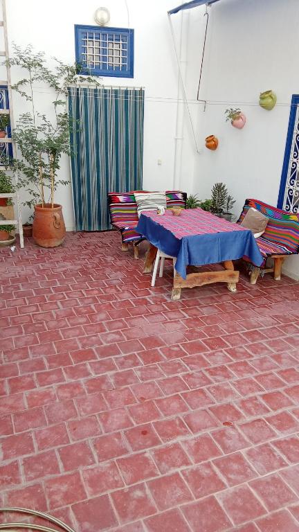 a patio with a table and chairs on a brick floor at Maison d'hôte Chama in Kairouan