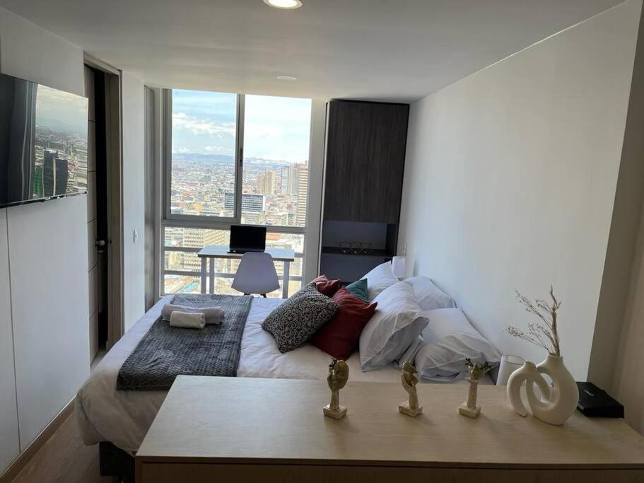 a bedroom with a large bed with a large window at living ventto calle 18 in Bogotá