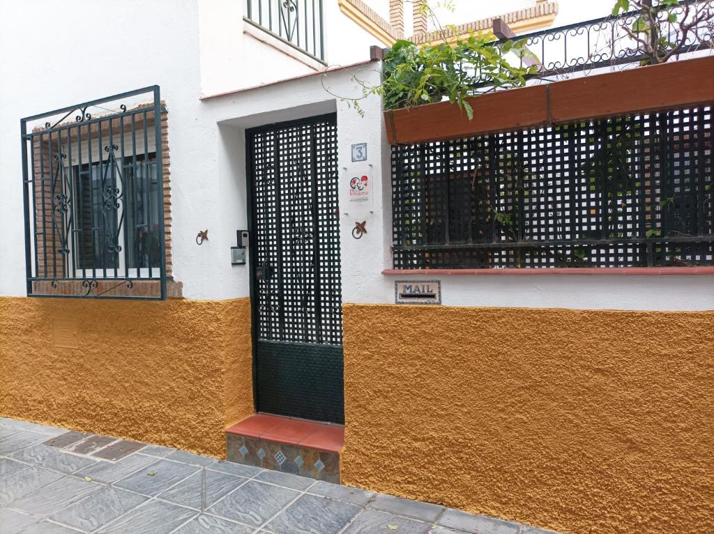budynek z czarno-żółtą ścianą i drzwiami w obiekcie Casa de la Portuguesa, bonita terraza con barbacoa w mieście Güéjar-Sierra