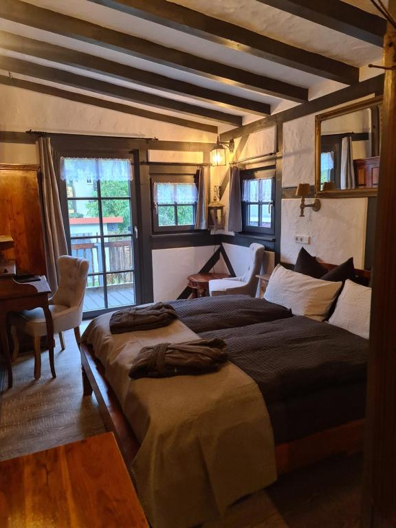 a bedroom with two beds and a desk and windows at Hotel b&b altes hinterhäusel in Freiberg