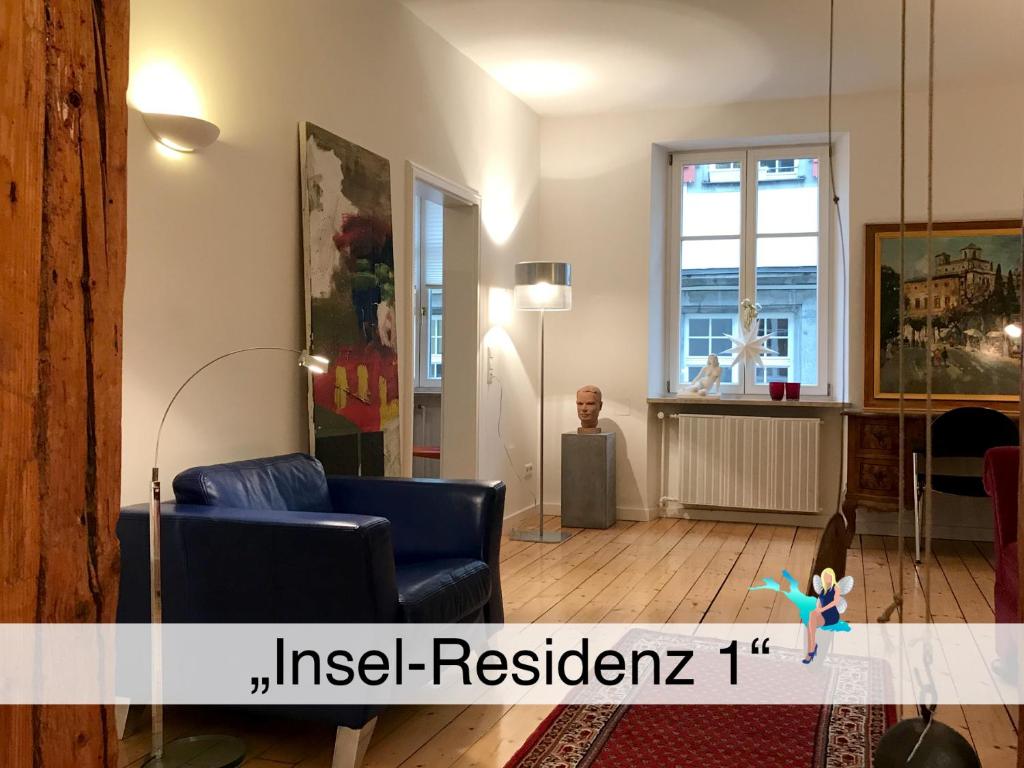 林道的住宿－Ferienwohnung Insel-Residenz 1，客厅设有蓝色的沙发和窗户。