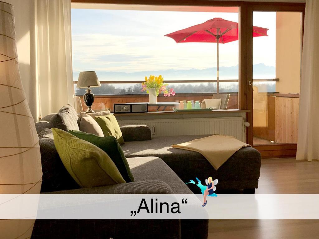 a living room with a couch and an umbrella at Ferienwohnung Alina in Kressbronn am Bodensee