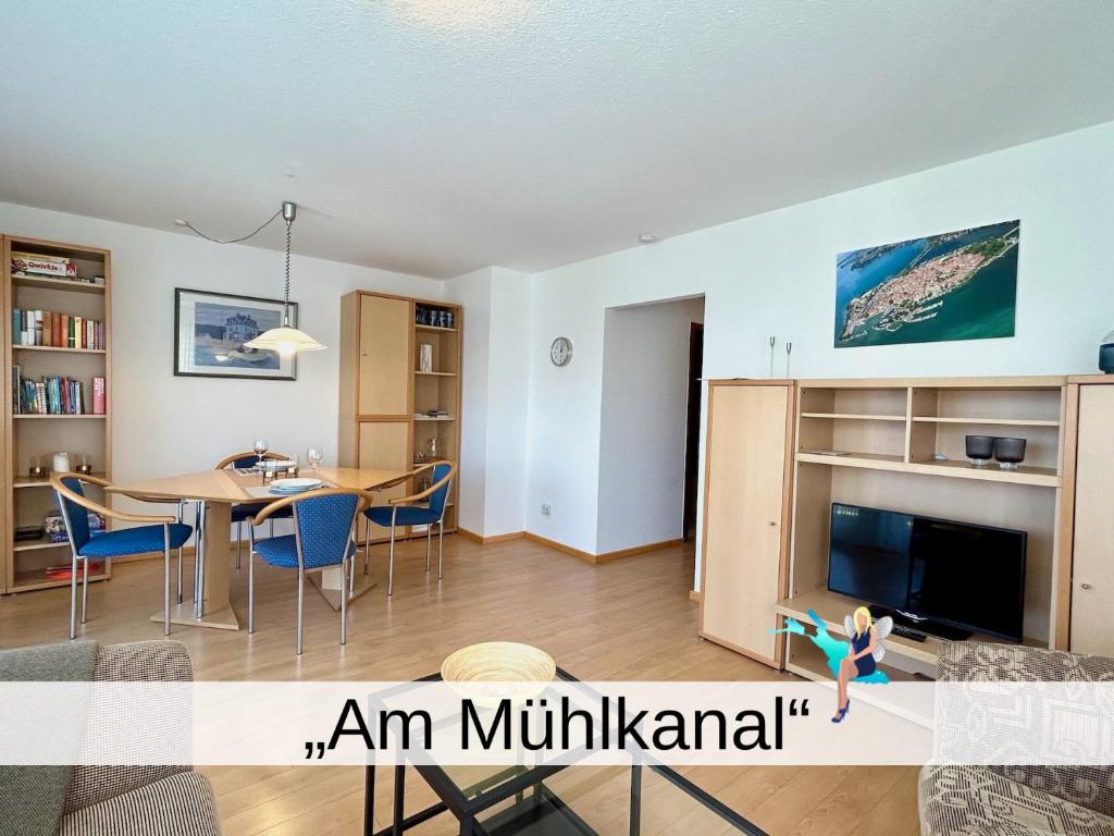 ein Wohnzimmer und ein Esszimmer mit einem Tisch und einem TV in der Unterkunft Ferienwohnung Am Mühlkanal in Langenargen