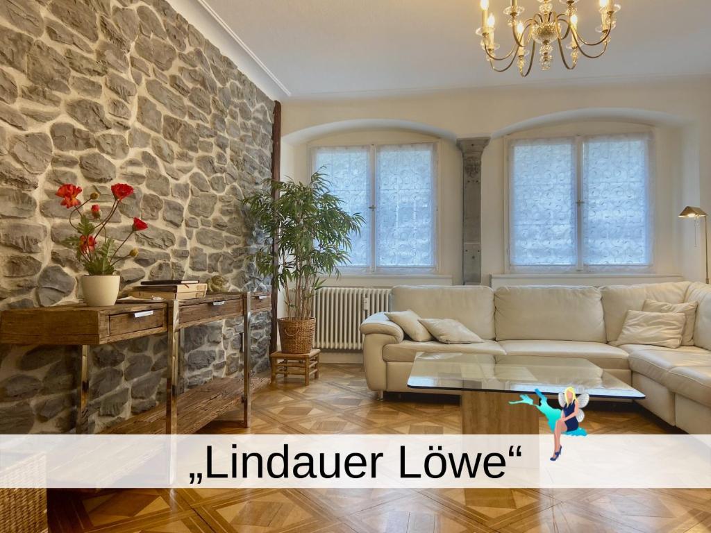a living room with a couch and a stone wall at Ferienwohnung Lindauer Löwe in Lindau