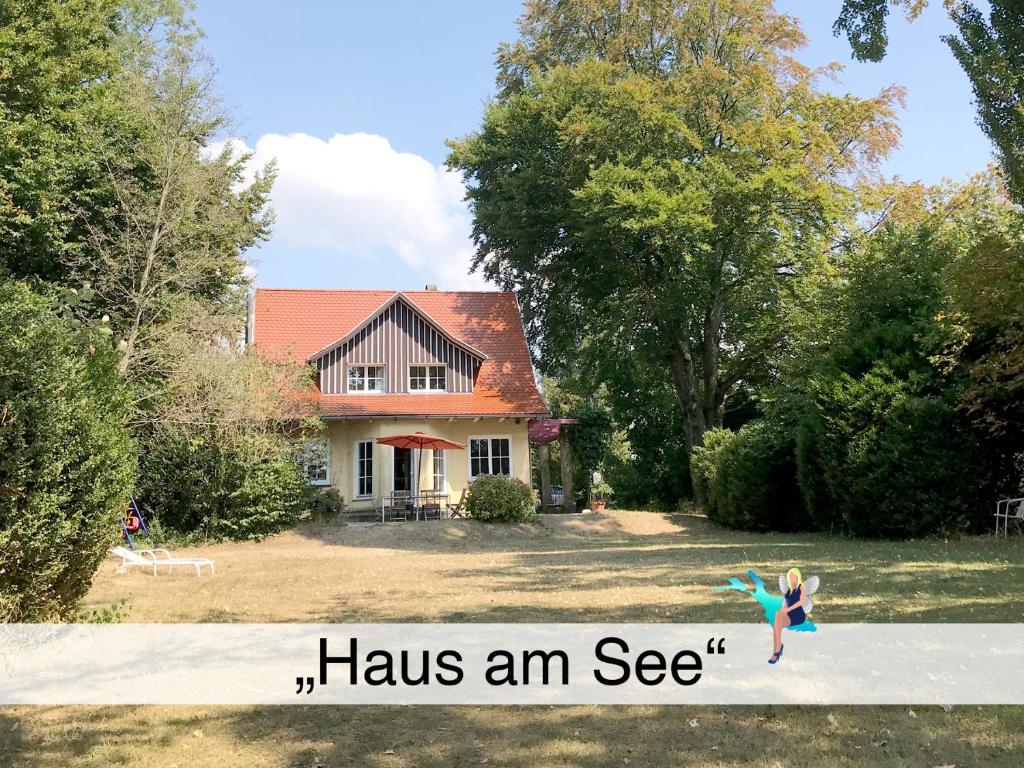 a young girl is jumping in front of a house at Haus am See in Wasserburg am Bodensee