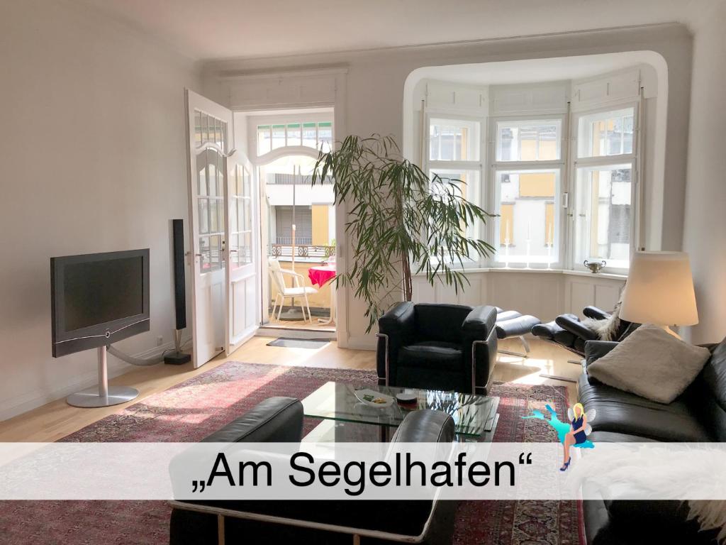 een woonkamer met een bank en een tv bij Ferienwohnung am Segelhafen in Lindau