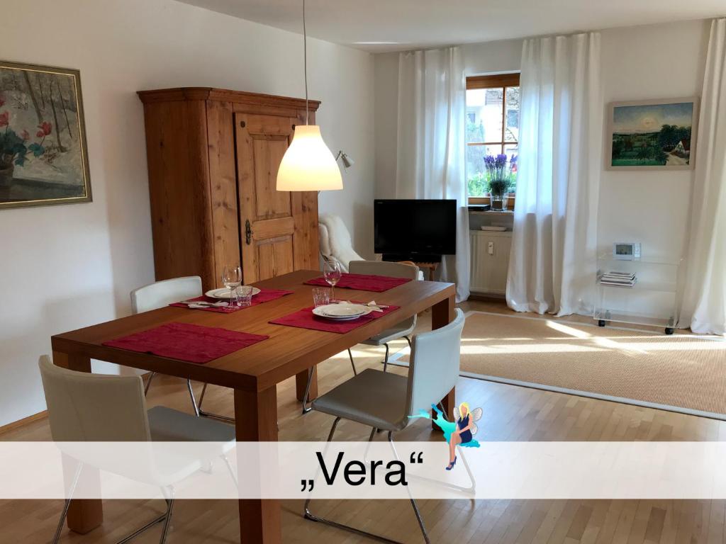 ein Wohnzimmer mit einem Holztisch und Stühlen in der Unterkunft Ferienwohnung Vera in Lindau-Bodolz