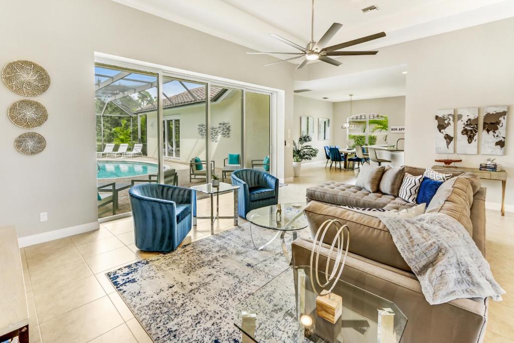 a living room with a couch and a table at Modern home w screened pool, hot tub, & comm amenities! in Naples
