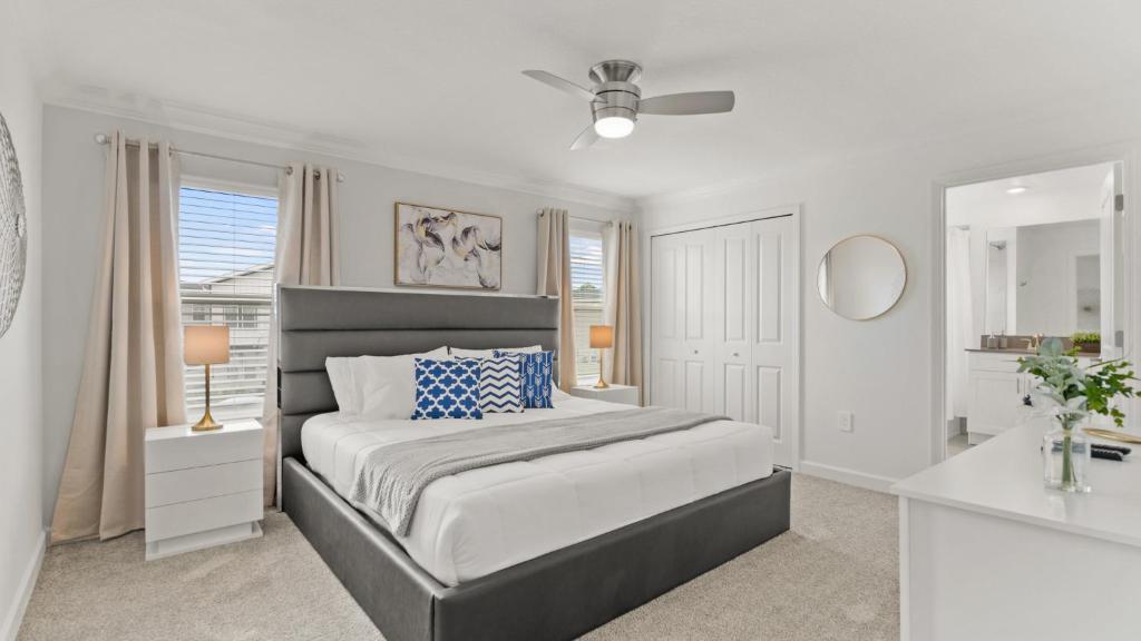 Habitación blanca con cama y espejo en Stunning Townhouses 5 Minutes away Disney!, en Kissimmee