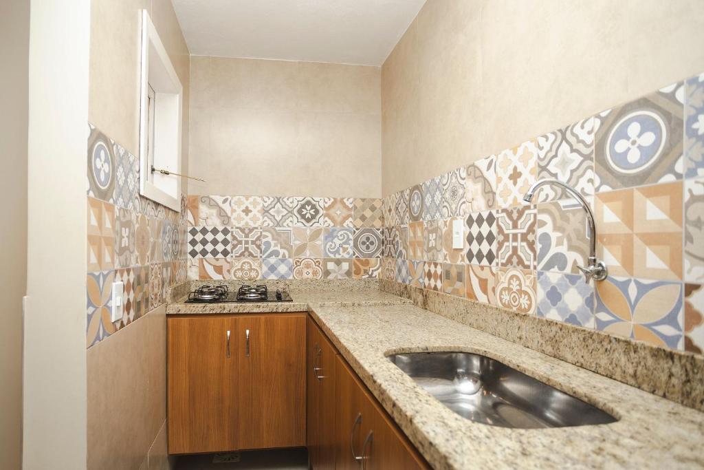 a bathroom with a sink and tiles on the wall at Solar da Teresa in Búzios