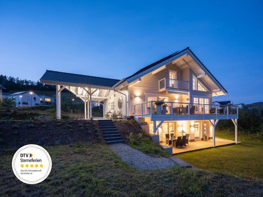 una casa grande con una terraza grande por la noche en Weinberg Holiday Idyllische Ruhe, nahe den Weinbergen, en Traben-Trarbach