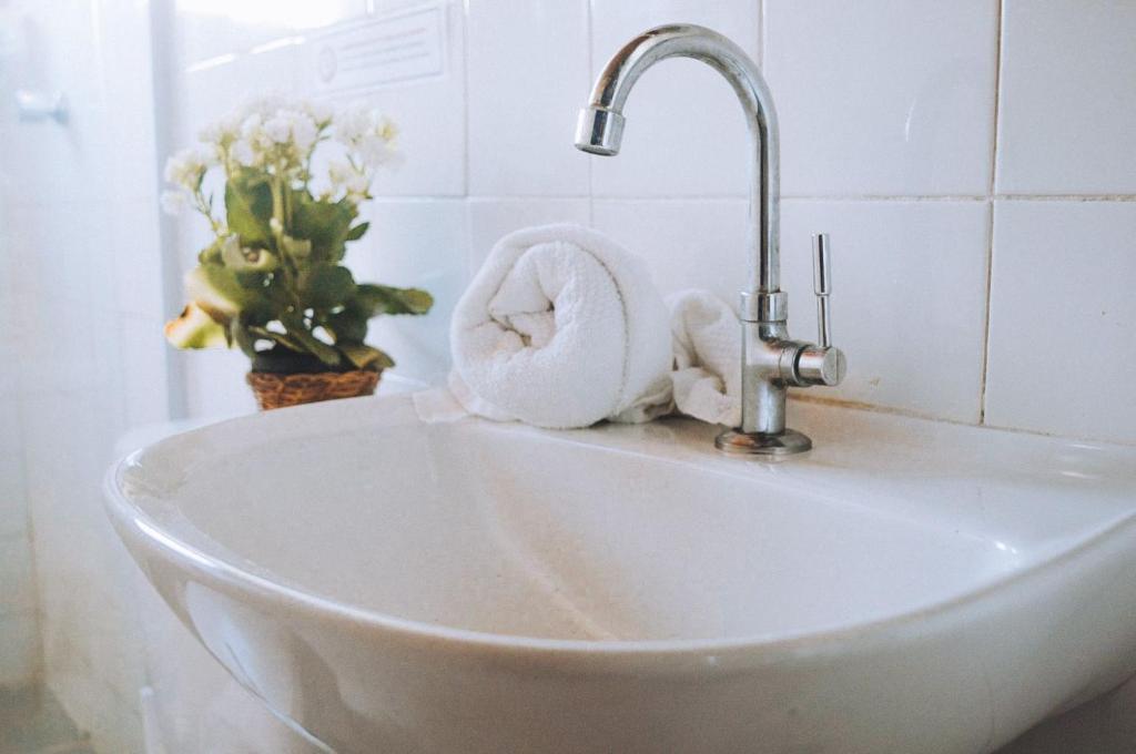 a white sink with a faucet and a towel at Pousada Beija Flor in Salvador