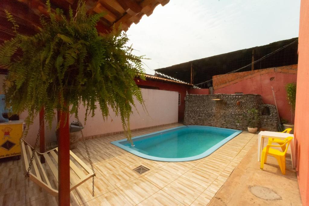 einen kleinen Pool auf einer Terrasse mit Palmen in der Unterkunft Hostel toca do Noel e Bia in Várzea Grande