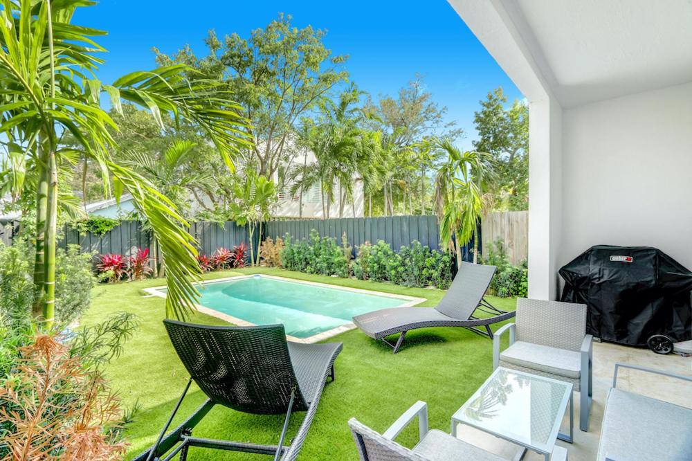 une cour avec une piscine et des chaises dans l'établissement Private pool, pool table, near beach, à Miami