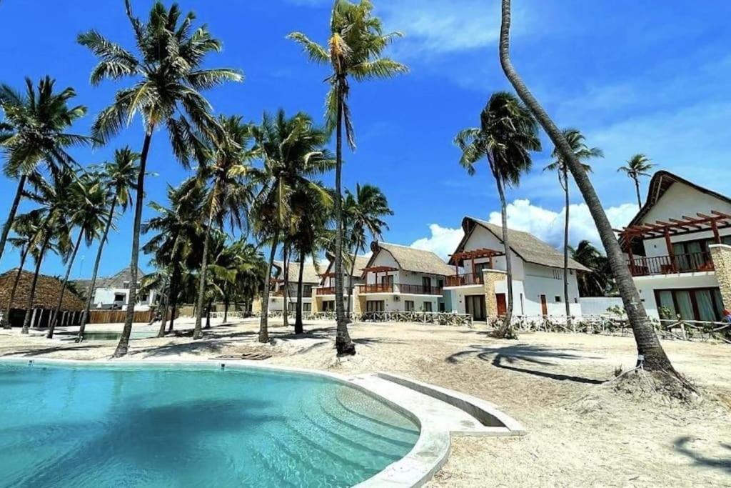 a resort with a swimming pool and palm trees at Ocean Front Villa with pool, Zanzibar in Pingwe