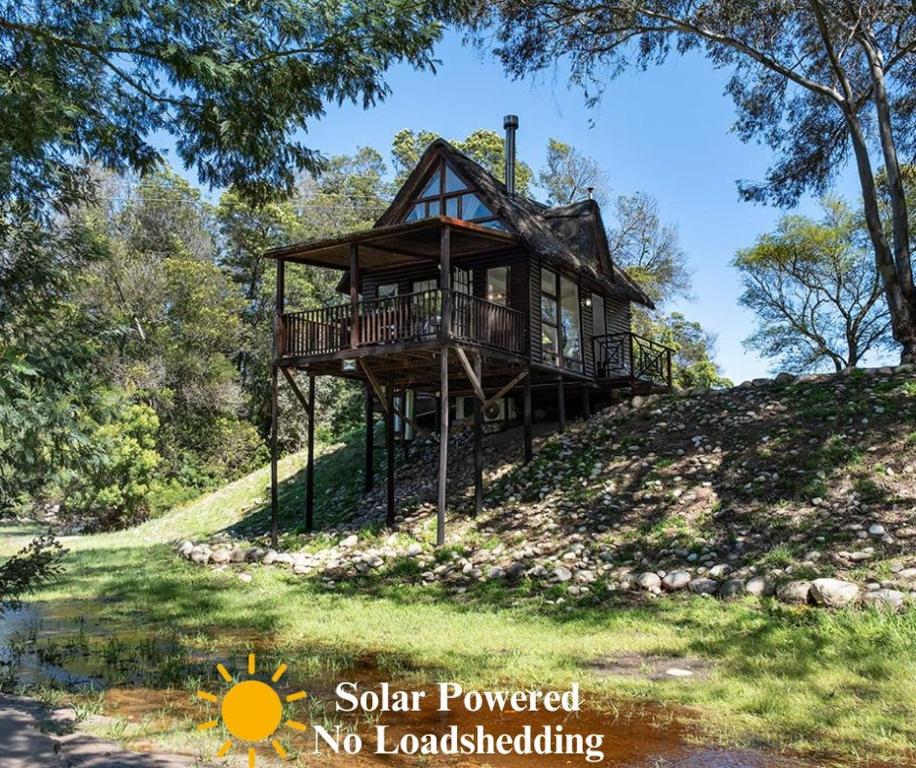 uma casa numa colina com as palavras energia solar sem paisagismo em La Ferme Guest Farm em Franschhoek