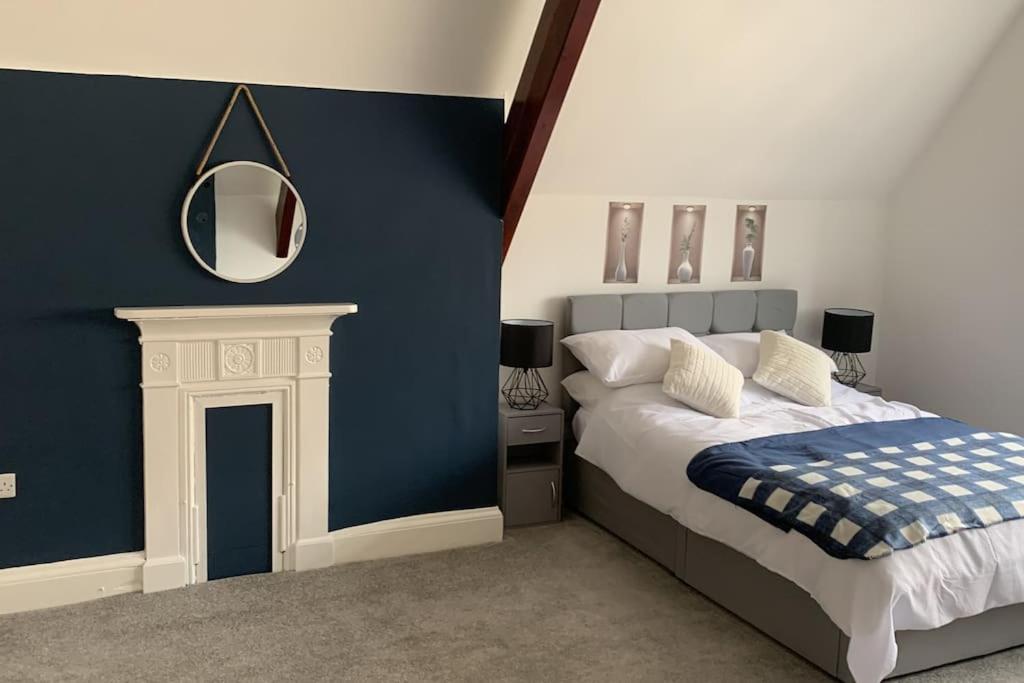 Schlafzimmer mit einem Bett und einem Wandspiegel in der Unterkunft Fantastic 2 bedroom apartment in Sunderland