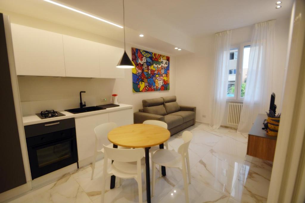 a kitchen and living room with a table and chairs at ARIOSTO HOME in Palermo