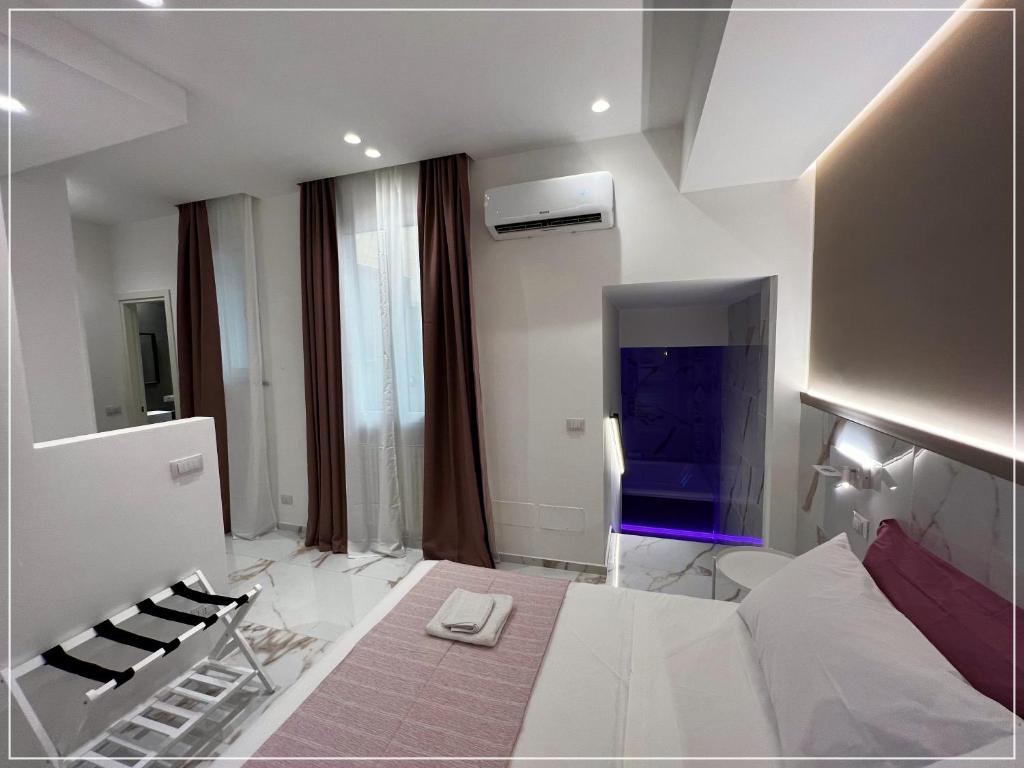 Habitación blanca grande con cama y TV. en ARIOSTO HOME, en Palermo