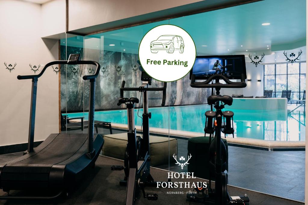 una sala de fitness con un gimnasio con TV y cintas de correr en Hotel Forsthaus Nürnberg Fürth, en Fürth