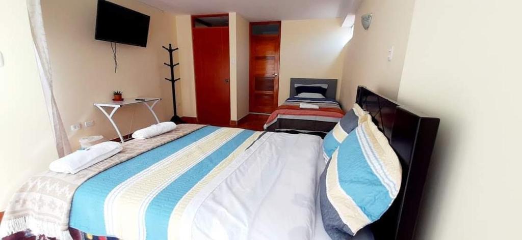sypialnia z dużym łóżkiem i telewizorem w obiekcie Casa Familiar Guadalupe Cusco w Cuzco