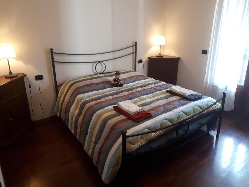 a bedroom with a bed with a striped comforter at Grande appartamento I Faggi in Abetone