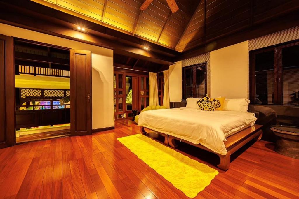 a bedroom with a large bed and a yellow rug at 夏日马卡龙系列 四卧三卫 私人泳池 in Bangkok