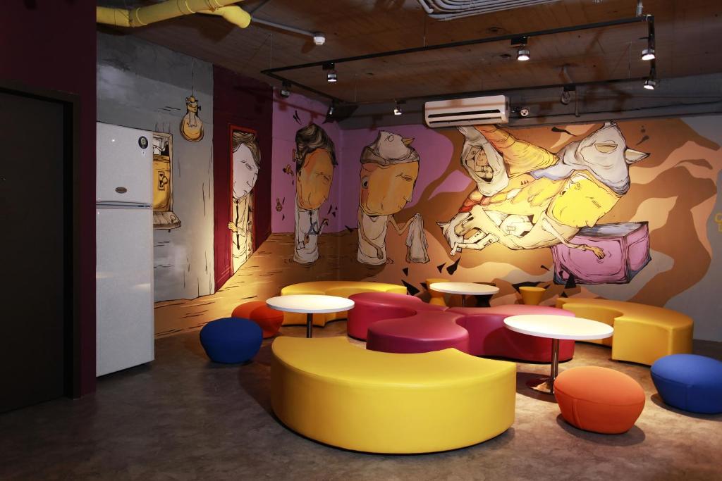 a room with tables and chairs and a mural at Backpackers Hostel - Ximen in Taipei