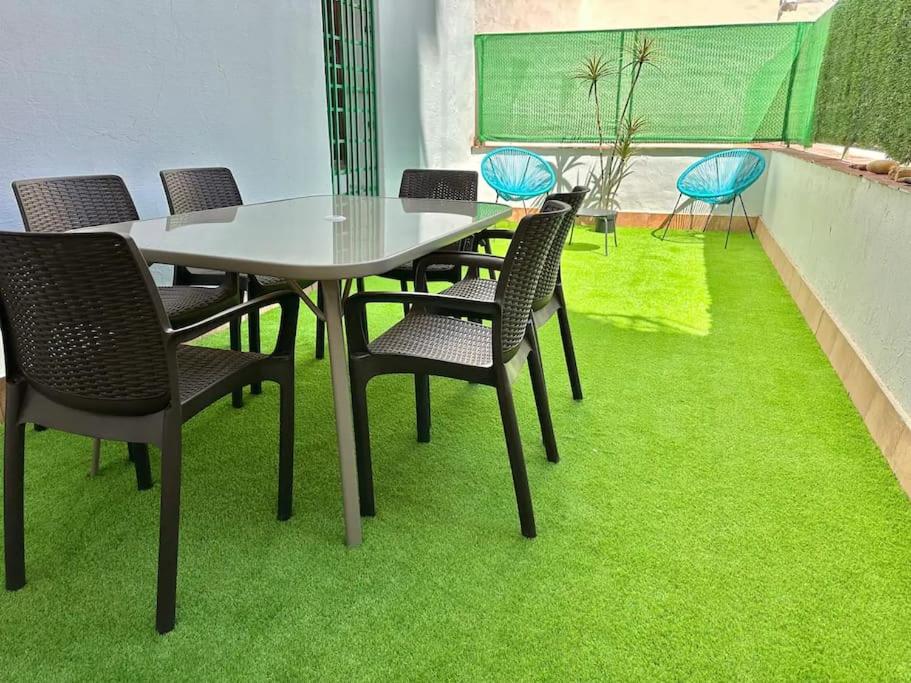 una mesa y sillas con césped verde en el suelo en La Ibiza del Pilar ComoTuCasa, en Zaragoza