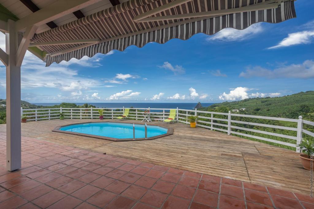 une terrasse avec une piscine et une clôture dans l'établissement Bungalow avec piscine au cœur de la campagne Vert, à Sainte-Marie
