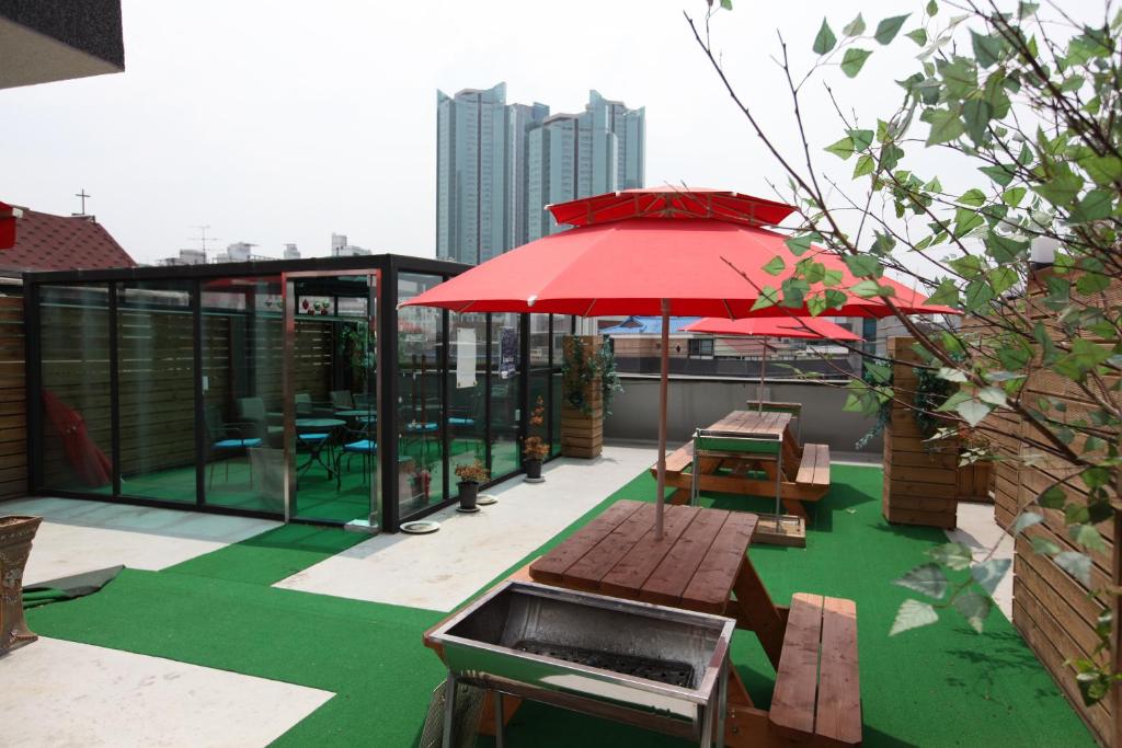 een patio met een rode parasol en banken op een dak bij Lombard House in Seoul