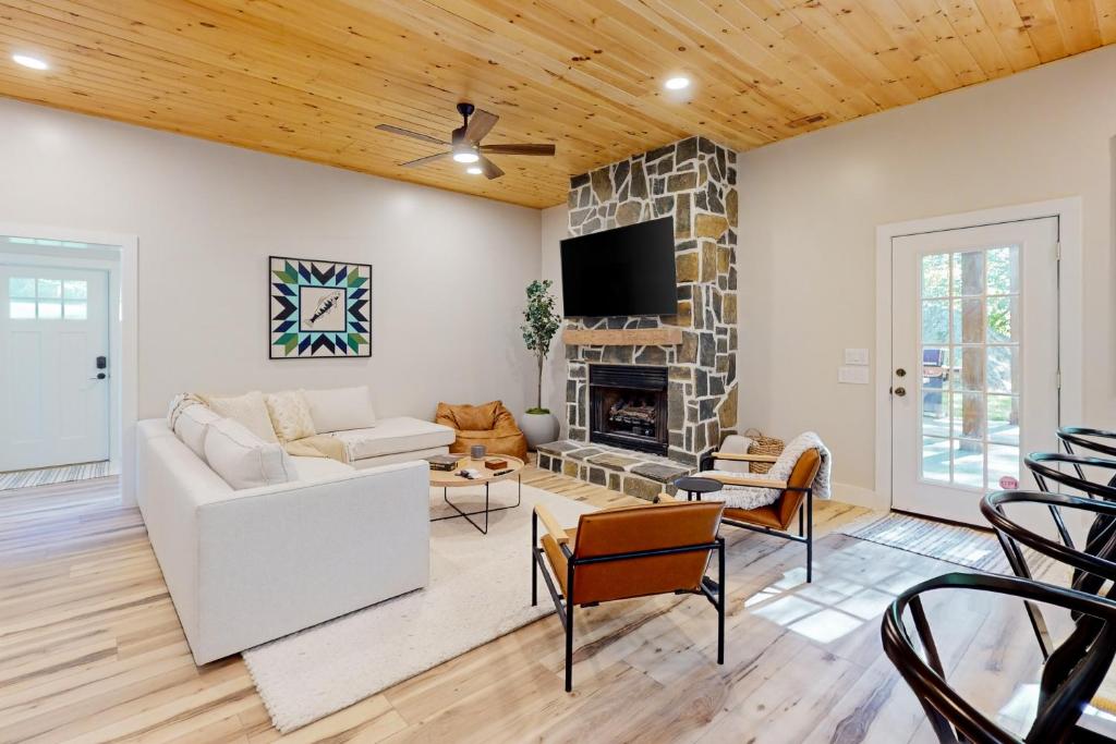 a living room with a white couch and a fireplace at River Rock Cottage in Boone