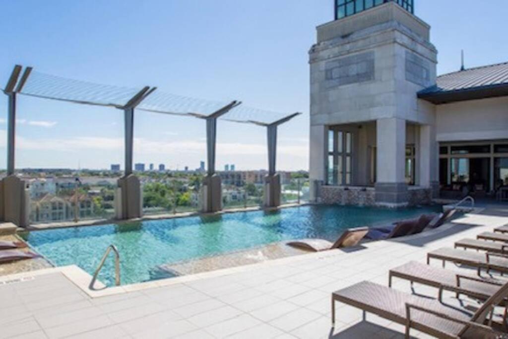 a swimming pool on top of a building with chairs at The Bentler #1 in Houston