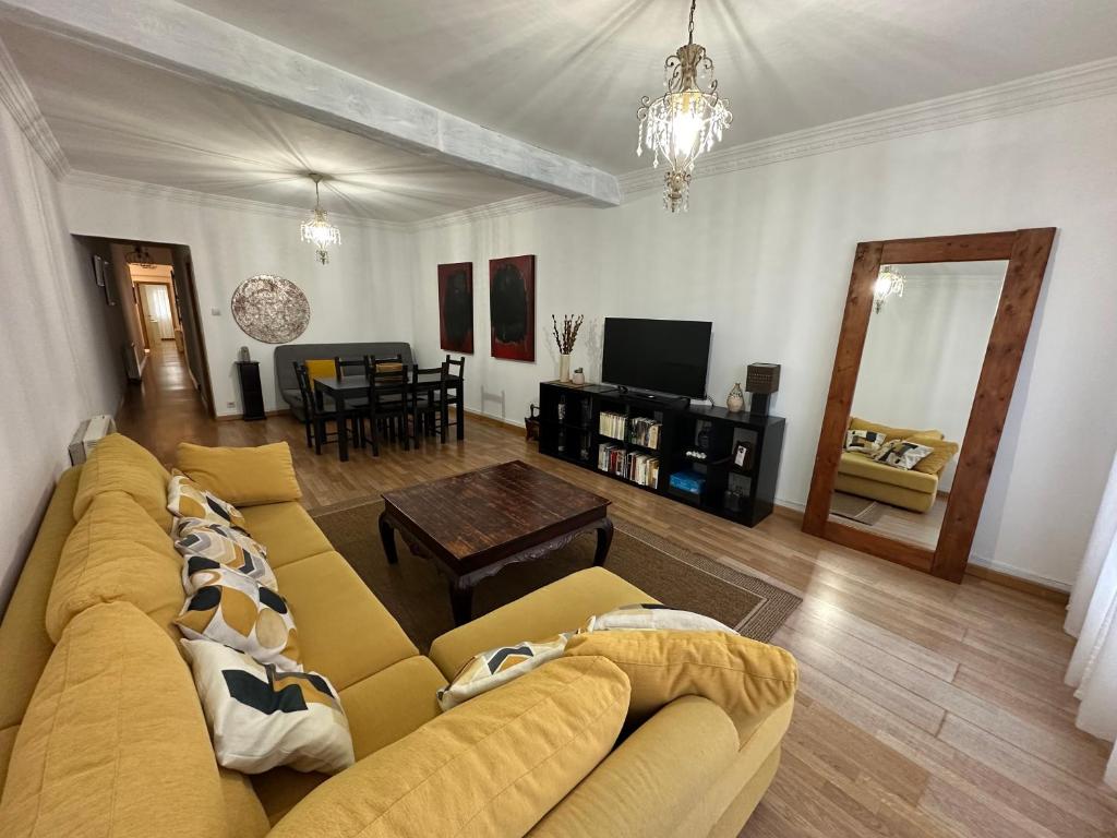 a living room with a yellow couch and a table at Centro Monumental in Pontevedra