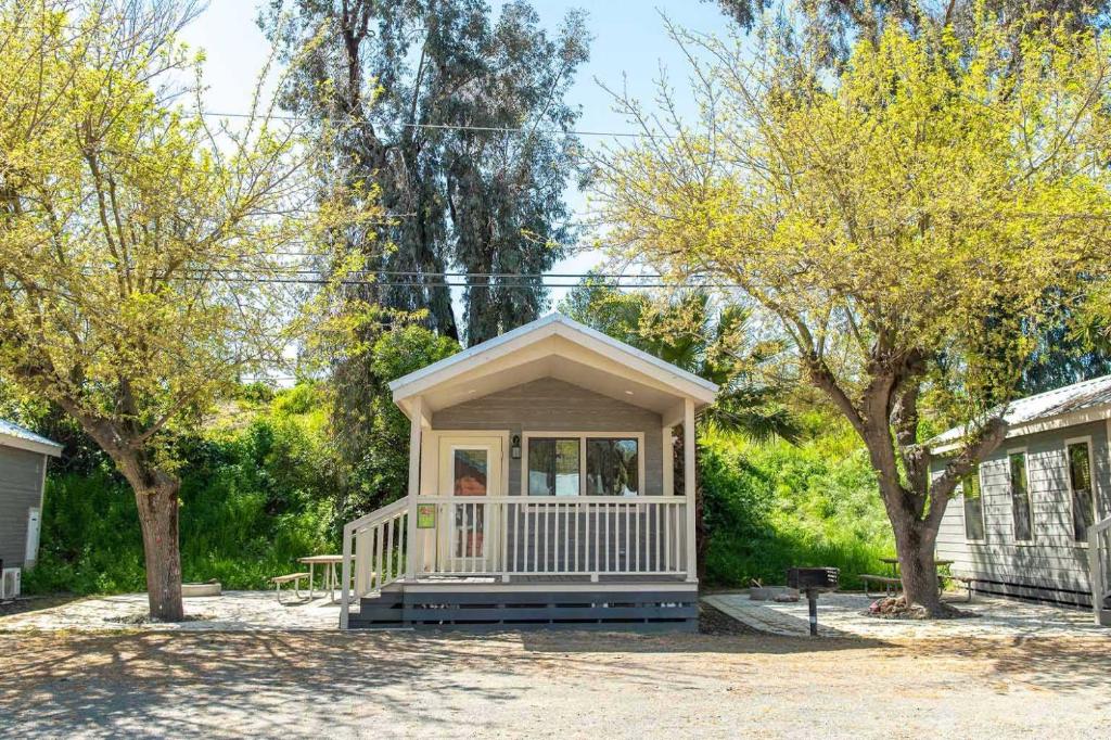 a small house in a yard with trees at Jellystone Park Tower Park Resort in Lodi